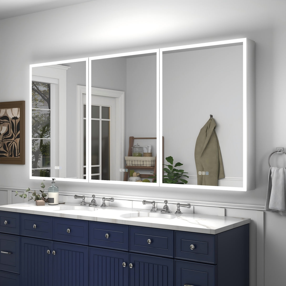 Bathroom with a large illuminated mirror above two sinks with blue cabinets.
