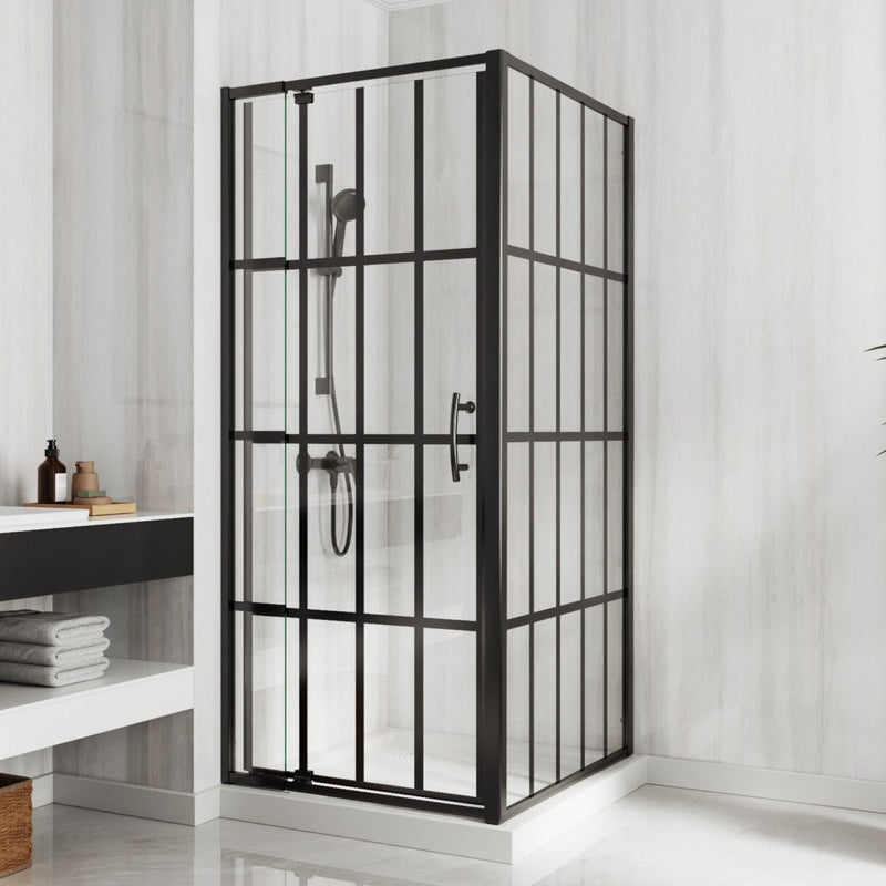 Corner shower enclosure with black metal frame and glass panels in a bathroom setting.