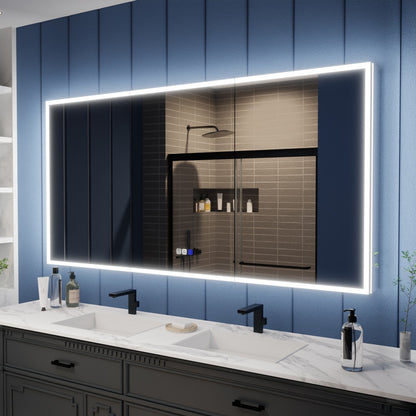 Bathroom vanity with a large illuminated mirror against a blue paneled wall.