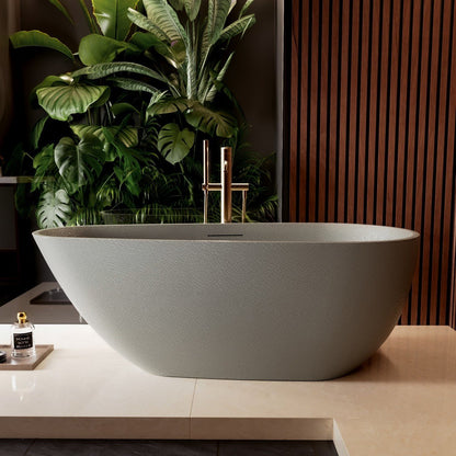 Modern freestanding bathtub in a bathroom setting with plants and a wooden wall.
