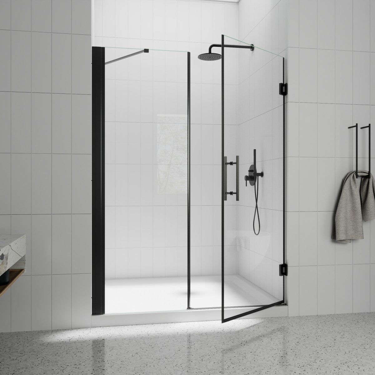 Modern shower setup with glass enclosure, black fixtures, and towel in a tiled bathroom.
