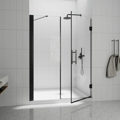 Modern shower setup with glass enclosure, black fixtures, and towel in a tiled bathroom.